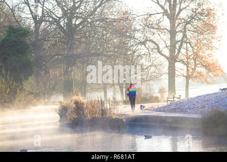 Northampton, UK. 4th Dec 2018. UK Weather: A bright, frosty morning with mist rising from tthe lake in Abington Park, people walking are wrapped up against the cold weather. Credit: Keith J Smith./Alamy Live News Stock Photo