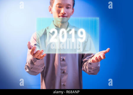 Businessman showing growing financial chart and target achievement in 2019 on virtual screen. Business concept. Happy New Year 2019 Stock Photo