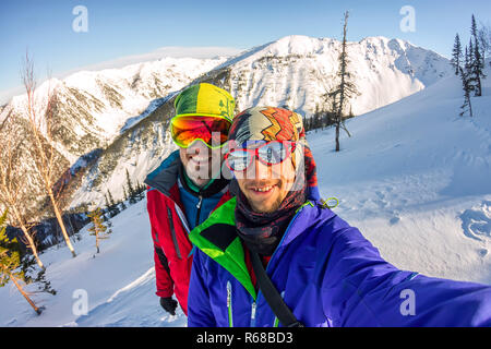 Selfie couples men skiers freeriders in snowy mountains Stock Photo