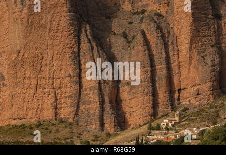 The Conglomerate pinnacles and cliffs of the Mallos de Riglos, towering above Riglos village and church, Aragon, Spain. Stock Photo