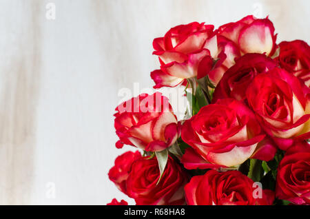Red roses bouquet over white wooden table. Stock Photo
