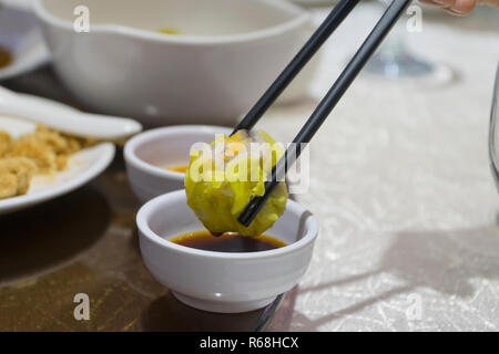 Dim sum by chopsticks dip in the sauce Stock Photo