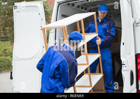 Two Delivery Men Unloading Shelf From Truck Stock Photo