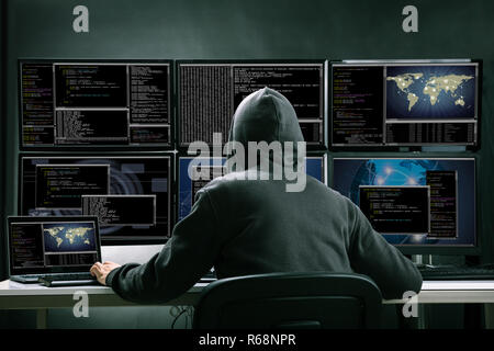 Hacker Using Multiple Computers For Stealing Data Stock Photo