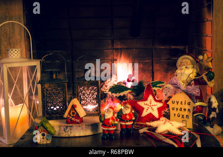 Health Love Luck' Christmas decoration with ornaments, candles, creations and Santa Claus in front of the firelace. Stock Photo