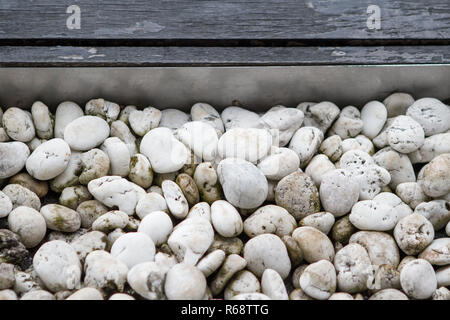 The dirty white stone is on a black plank. Stock Photo