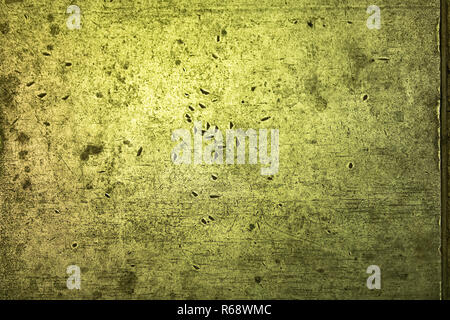 Scratches in a solid metal surface in green light. Stock Photo