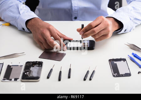 Technician Repairing Mobile Phone Stock Photo