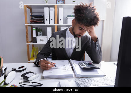 Unhappy Businessman Working In Office Stock Photo