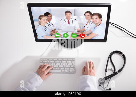 Doctor Video Conferencing With Medical Team On Computer Stock Photo
