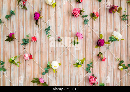 Wall of wooden boards decorated with flowers. Beautiful background for photo studio. Part of interior. Stock Photo