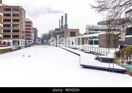 Rotterdam, March 3, 2018: Frozen and snow-covered Steigersgracht on a cold and grey winter day with the smoking chimneys of the city energy plant Stock Photo
