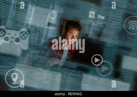 Young concentrated indian computer developer writing new code Stock Photo