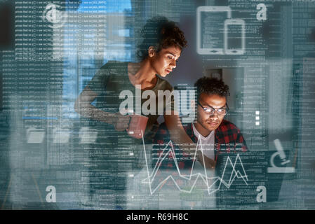 Young indian developer and his project manager discussing application code Stock Photo