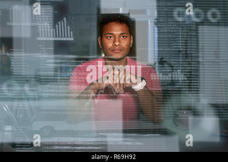 Young spectacled concentrated indian data analyst using big data Stock Photo