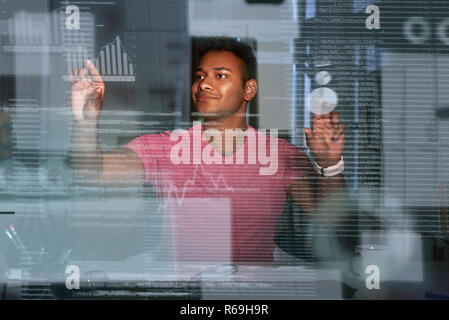 Young concentrated indian data analyst using big data to make solutions Stock Photo