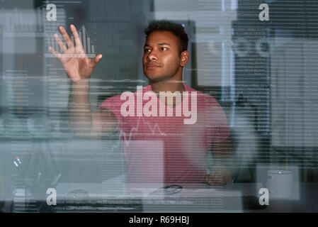 Young concentrated indian data analyst looking over the data Stock Photo