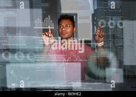 Young indian analyst is comparing data and make conclusions Stock Photo