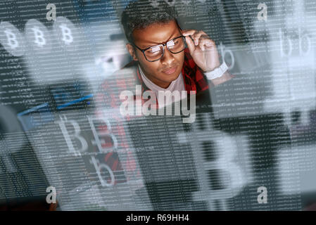 Young indian man mining cryptocurrency at night Stock Photo