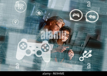 Young indian woman game developer and red haired man are laughting about idea Stock Photo