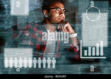 Young concentrated indian SEO specialist looking over advertising conversion Stock Photo