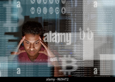 Close-up of young indian programmer thinking how to get more cryptocurrency Stock Photo