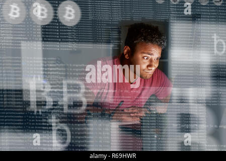 Young indian programmer thinking how to get more cryptocurrency Stock Photo
