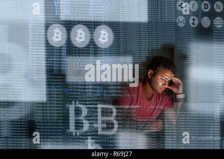 Young indian programmer thinking how to get more cryptocurrency Stock Photo