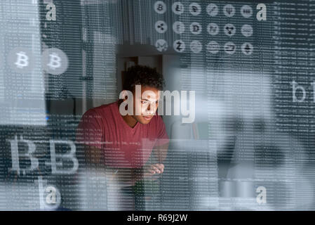 Young indian programmer thinking how to get more cryptocurrency Stock Photo