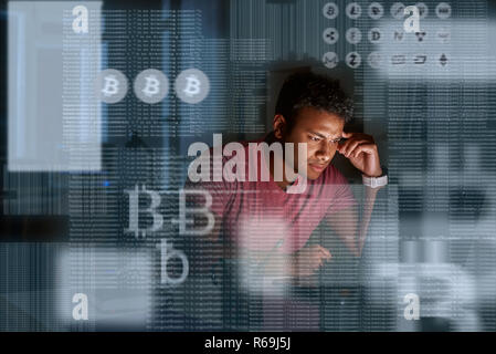 Young indian programmer thinking how to get more cryptocurrency Stock Photo