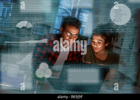 Young concentrated indian data analysts looking over the data Stock Photo