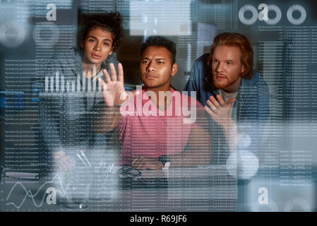 Young team of data analysts are looking over the data Stock Photo