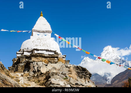 Old white stupa and prayer flags near Pangboche with Ama Dablam in the background, Everest Base Camp trek, Sagarmatha National Park, Nepal Stock Photo