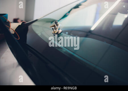Glazier using tools repairing fix crack windshield Stock Photo