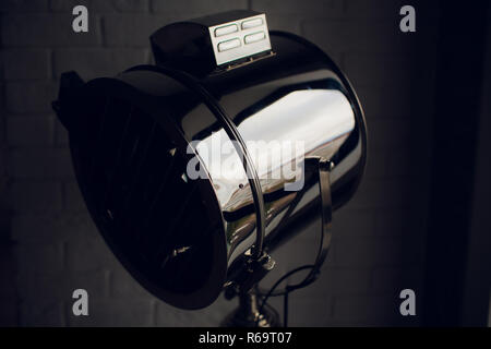 set retro spotlights on tripods in grunge wall background with copy space and text Stock Photo