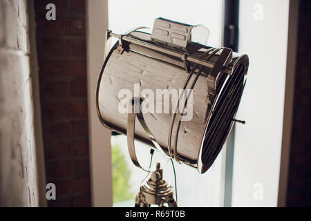 set retro spotlights on tripods in grunge wall background with copy space and text Stock Photo