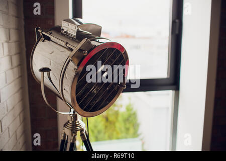 set retro spotlights on tripods in grunge wall background with copy space and text Stock Photo