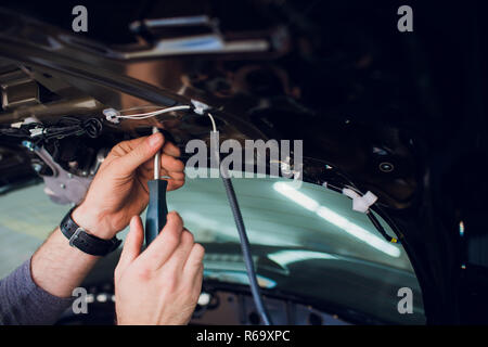 Mechanic installing car central door lock motor. Stock Photo