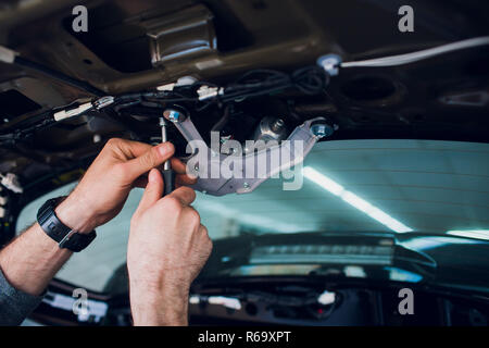 Mechanic installing car central door lock motor. Stock Photo