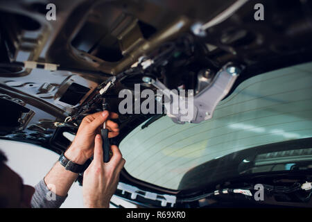 Mechanic installing car central door lock motor. Stock Photo