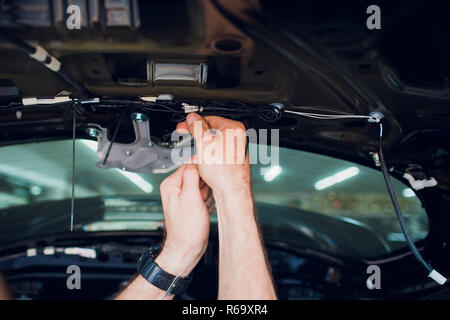 Mechanic installing car central door lock motor. Stock Photo