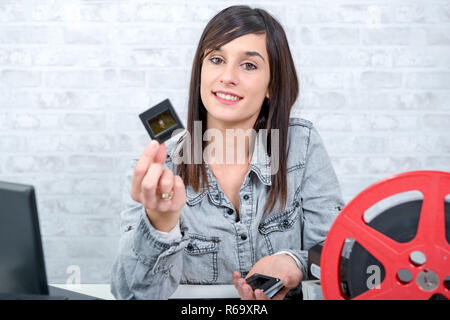 young brunette woman looking at film slide Stock Photo