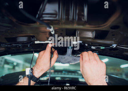 Mechanic installing car central door lock motor. Stock Photo