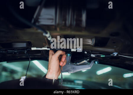 Mechanic installing car central door lock motor. Stock Photo