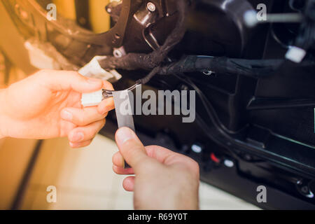 Mechanic installing car central door lock motor. Stock Photo