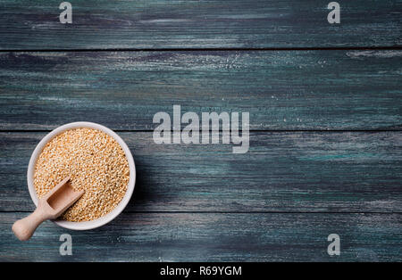 Organic quinoa seeds in a ceramic bowl on wooden green rustic table. It can be used to a gluten-free diet.Close up view. Stock Photo