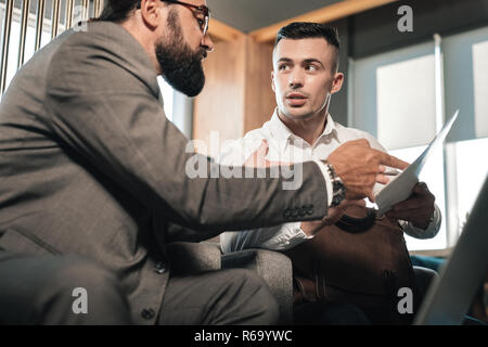 Young handsome economist speaking with employer before the meeting Stock Photo