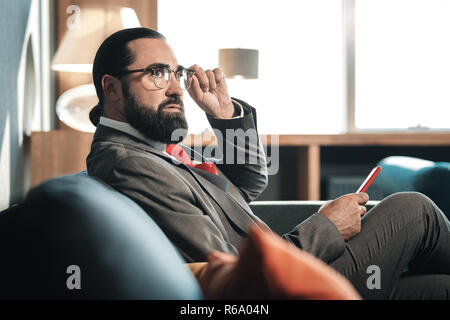 Stylish bearded man wearing nice business attire and red tie Stock Photo