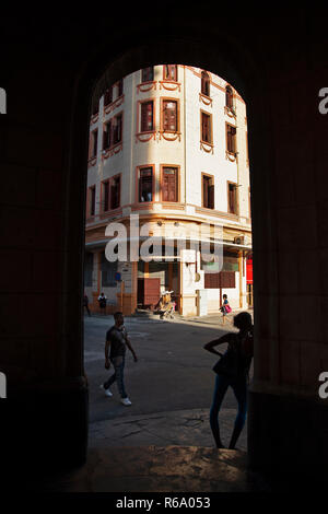 Framed in an black archway the silhouette of a Cuban girl hanging out on a street corner in Havana Cuba Stock Photo