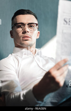 Close up of handsome young dark-haired man wearing glasses Stock Photo